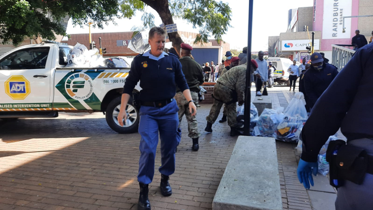 Photo: SAPS members confiscate goods during a raid in Randburg, north of Johannesburg. Author: Dinilohlanga Mekuto